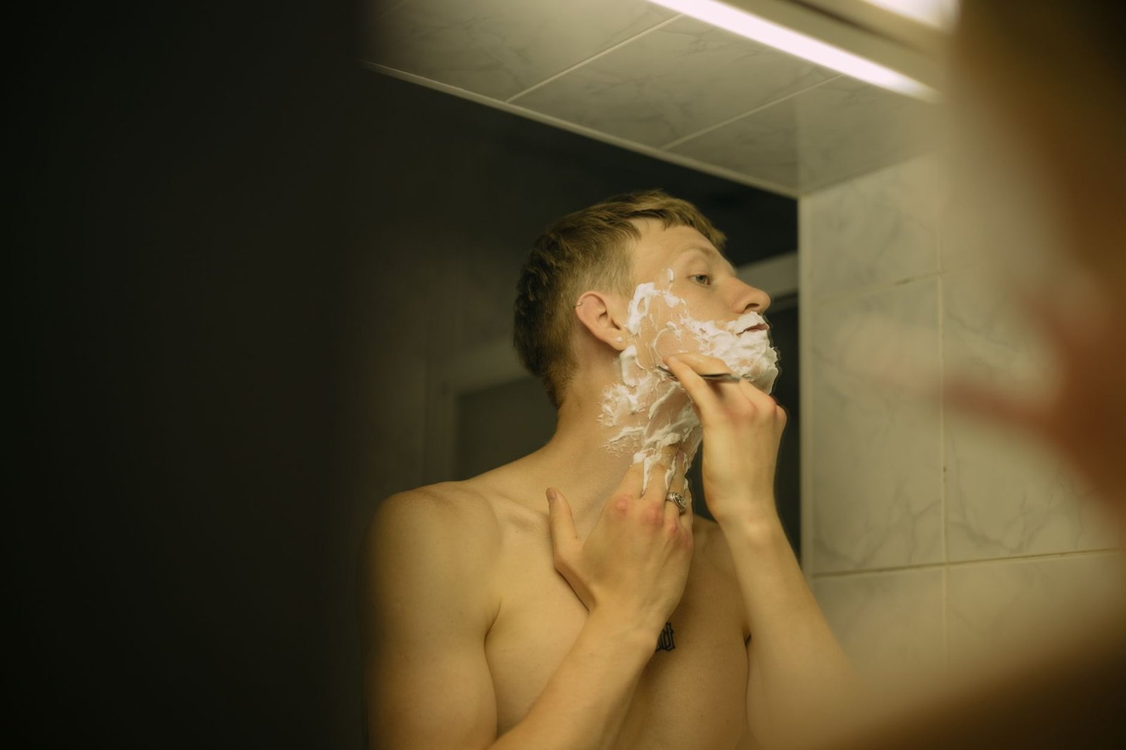 Hombre afeitándose ante el espejo