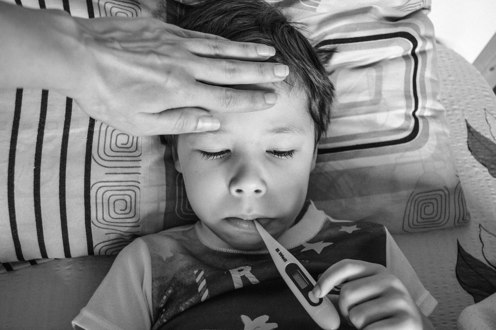 Niño en la cama con termómetro