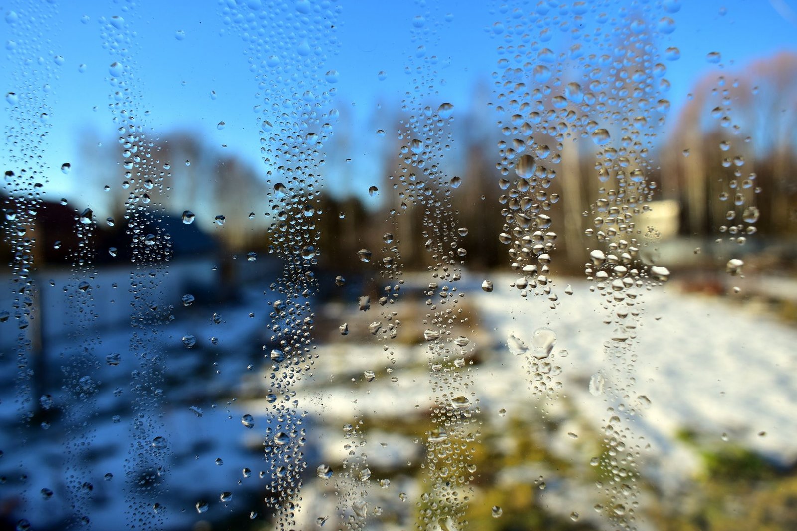 Cristal de una ventana empañado con gotas de condensación en invierno