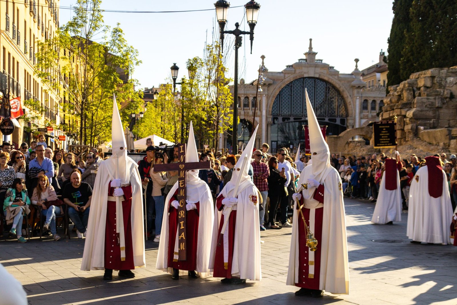 Procesión de Semana Santa por una calle estrecha al atardecer