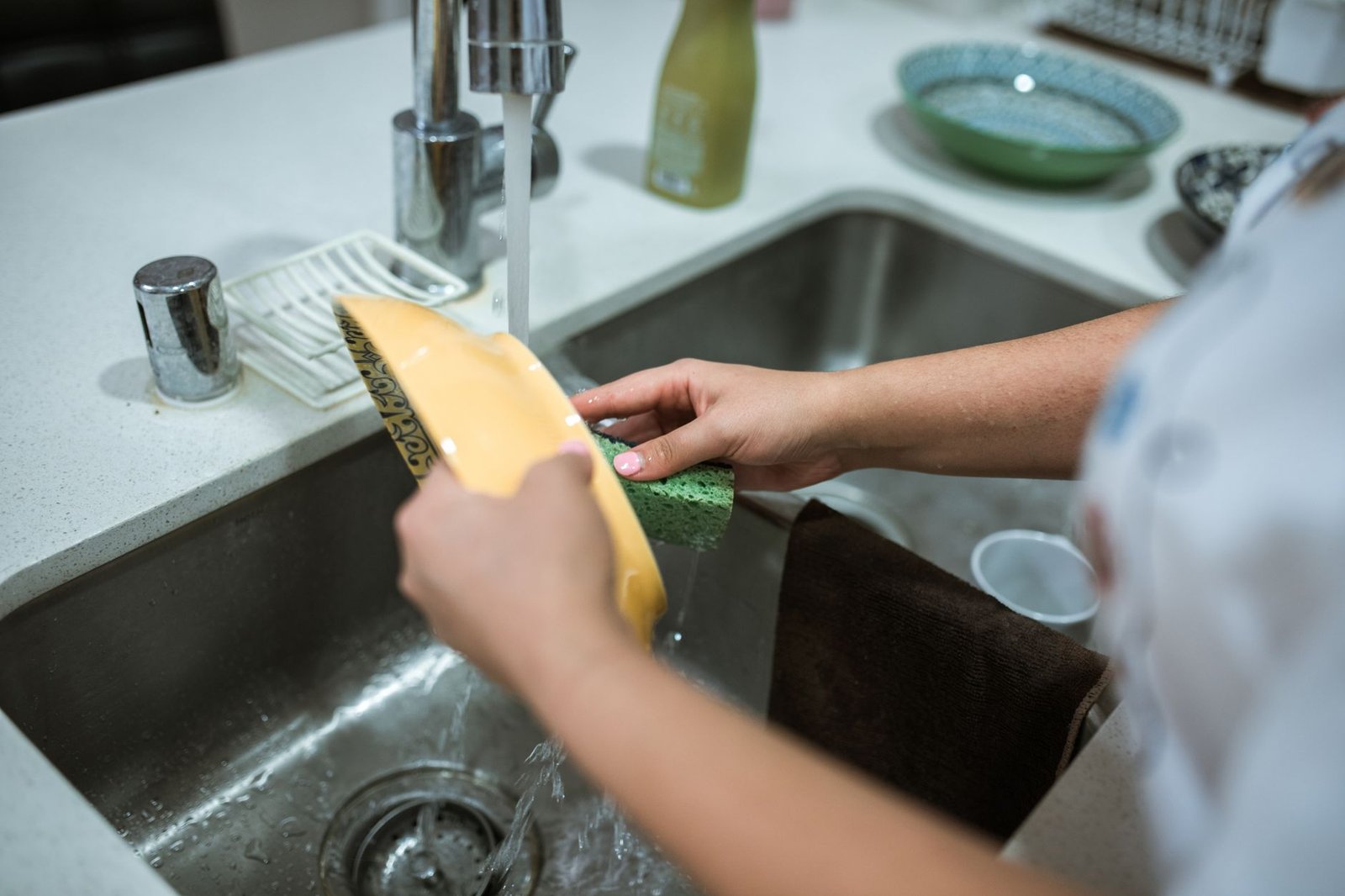 Fregadero de cocina limpio con guantes y utensilios de limpieza