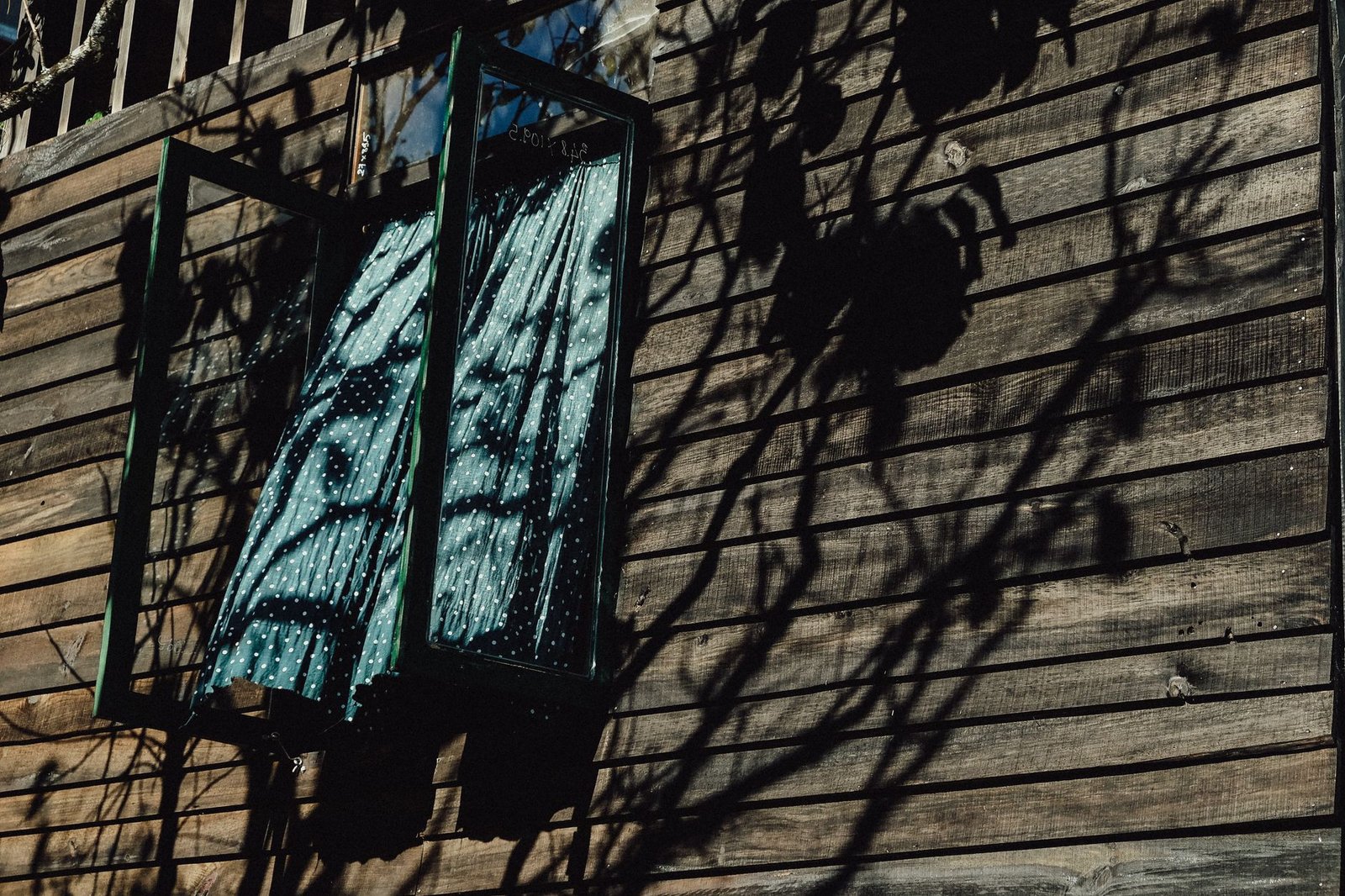 Ventana abierta con cortina fina movida por el aire en una habitación luminosa