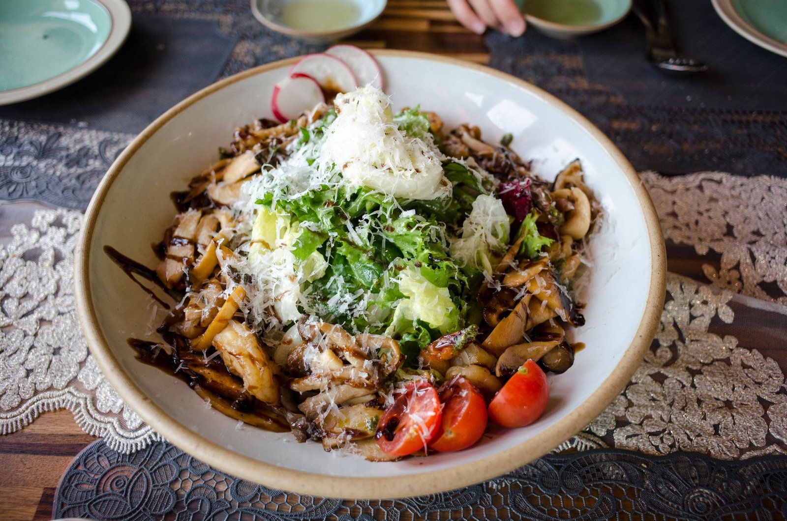 Plato de ensalada con setas salteadas sobre hojas verdes frescas