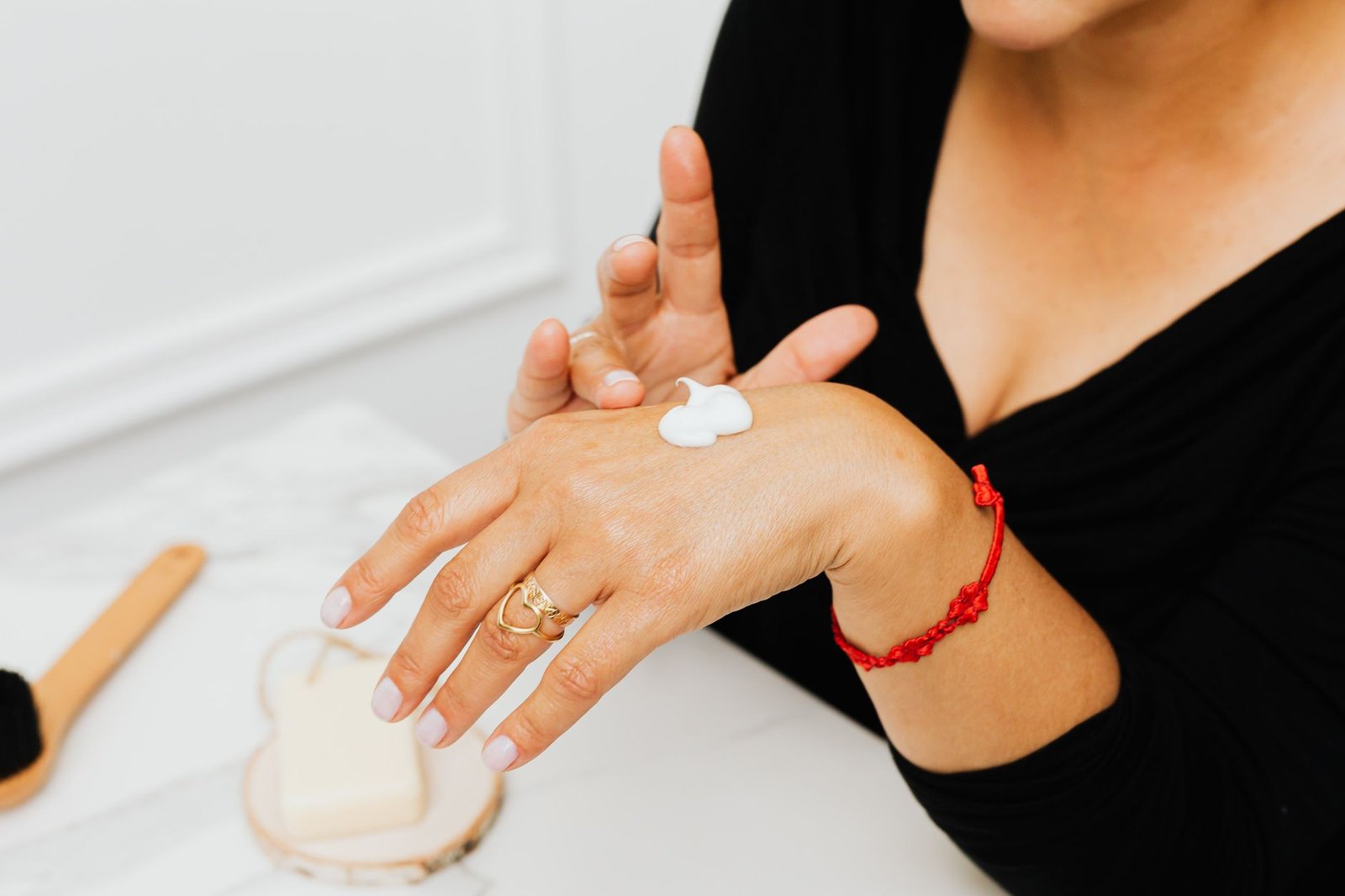 Manos de mujer aplicándose crema hidratante en invierno