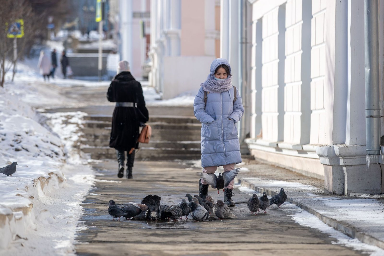 Mujer paseando con abrigo por una calle de la ciudad en invierno