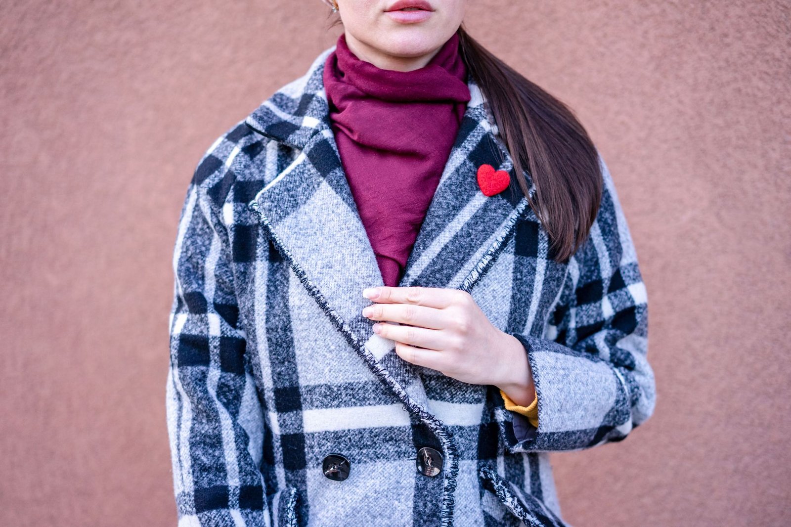 Mujer con abrigo, jersey y bufanda vestida por capas en invierno