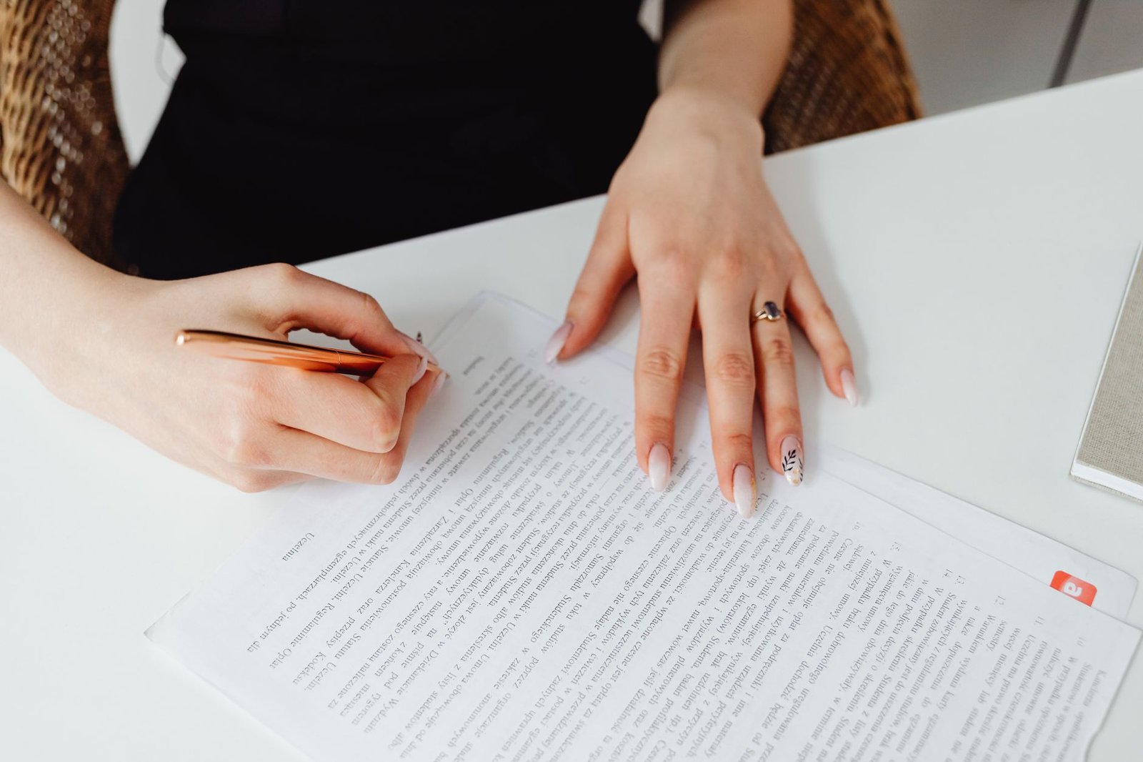 Mujer leyendo y firmando un contrato de trabajo sobre una mesa de oficina